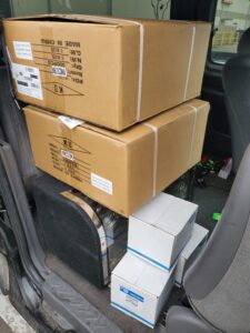 Two medium-sized boxed cargo placed inside the backseat of a van