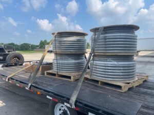 Two columns of stacked metal cylinders strapped to a flat bed of a truck